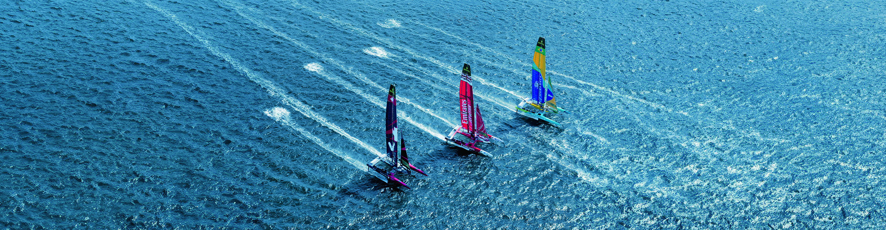 Three catamarans sailing in the water